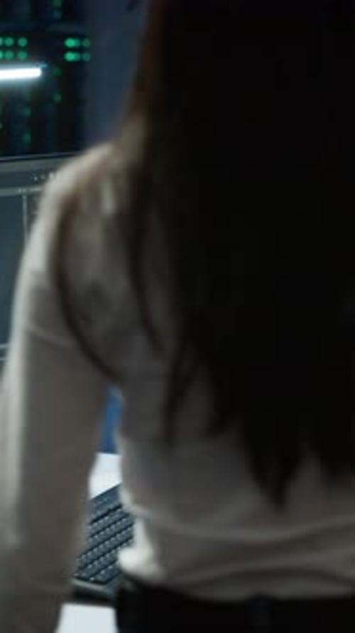 Vertical Video Engineer in Data Center Sitting Down at Desk Installing Software