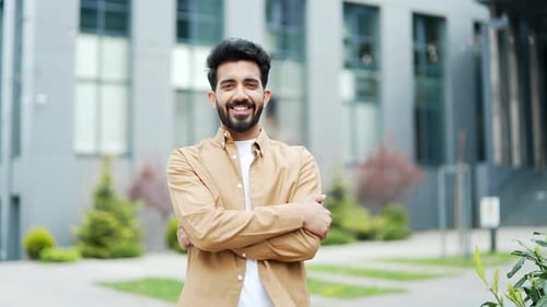Confident Man Smiling Outdoors With Arms Crossed