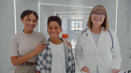 People Standing in Lobby of Hospital and Smiling at Camera