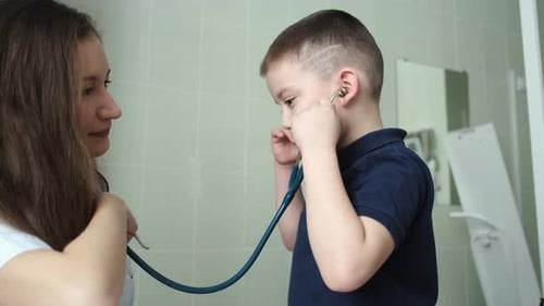 the doctor shows the child how the stethoscope works in the hospital