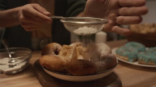 Sprinkling Powdered Sugar on Homemade Donuts