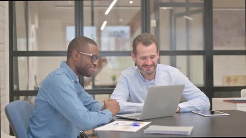 Two Men Collaborating on Laptop in an Office