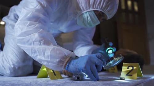 Crime Scene Investigator Examining Body with Handgun