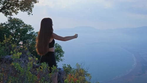 Back View of a Young Woman in Sportswear Warming Up Outdoors in the Morning