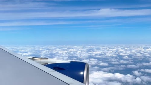 Passenger View Of Aeroplane Wing And Engine Flying Over Clouds. Aircraft Flight At Altitude.