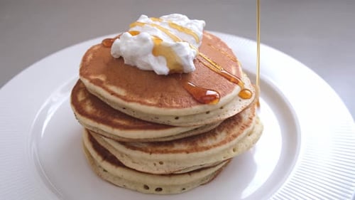 Pancakes with Whipped Cream and Syrup Drizzled On Top