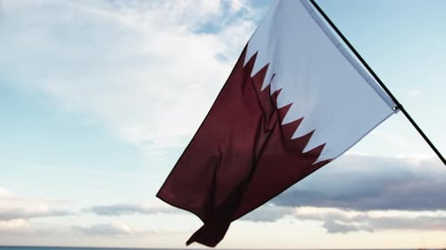 Qatar Flag Waving Gently Near the Ocean