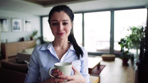 Woman Holding a Mug Smiling in Apartment