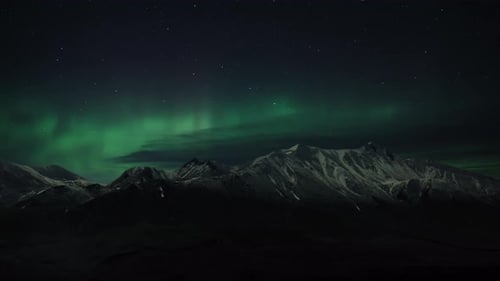 Northern Lights above snowy mountains