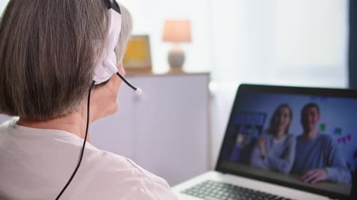 Senior Woman Video Chatting with Young Adult Couple