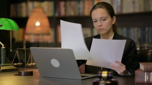 Female Lawyer Doing Paperwork with Laptop