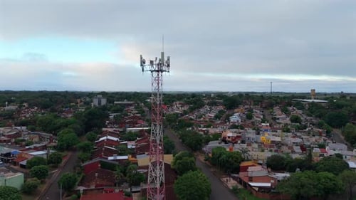 Telecommunications tower in Posadas Misiones with urban grid revealed by drone orbit Argentina
