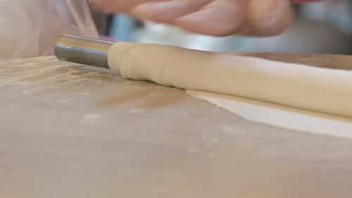 Adult Rolling Dough on Wooden Surface