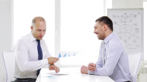 Business, Partnership, Finances and Office Concept - Two Smiling Businessmen Holding Papers