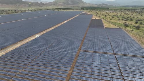 Weitläufige Luftaufnahme eines Solarparks in einer Wüstenlandschaft