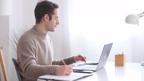 Junger Mann arbeitet am Laptop