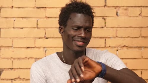 Man Checks Time on Smart Watch