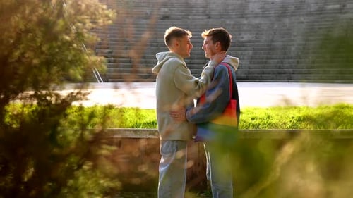 Young caucasian gay couple sharing intimate moments in a park