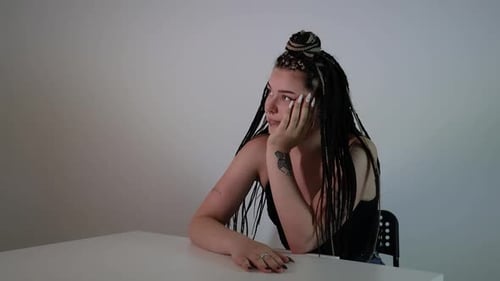 Contemplative woman sitting at table, pensive mood