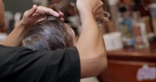 Barber Cutting Hair With Scissors and Comb Close Up