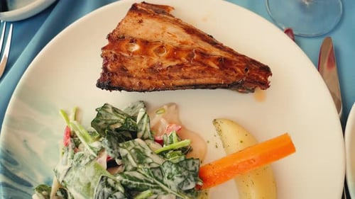 Grilled Trout Served with Salad and Steamed Vegetables in a Restaurant