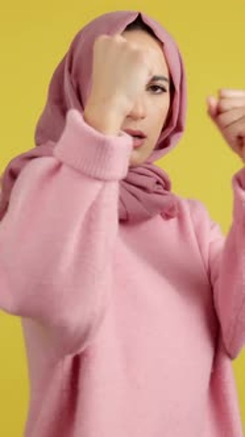 Young Woman in Headscarf Strikes Defensive Boxing Pose