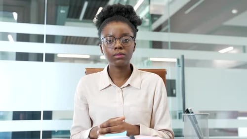 Webcam view. Focused african american female employee watching video call training looking at camera