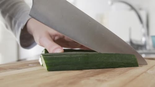 Cucumber Slicing on a Cutting Board in Kitchen