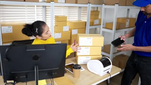 A female warehouse worker is receiving packages and verifying shipping information