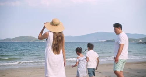 Asian Young Happy Family Enjoy Vacation on Beach in Evening Dad Mom and Children Relax Walking