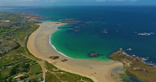 Luftaufnahme des ruhigen Strandes von Plage Des Amiets mit klarem türkisfarbenem Wasser und Wellen