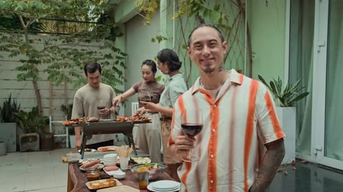 Friends enjoy a barbeque at home on sunny day