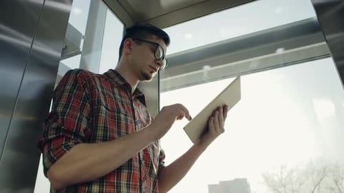 Hipster Manager trabajando en una computadora portátil junto a una ventana en cámara lenta