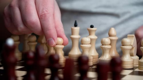 An unrecognizable man plays chess.