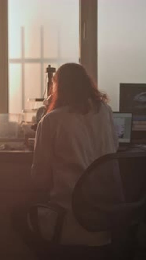 Scientist Using Microscope in Lab at Sunrise