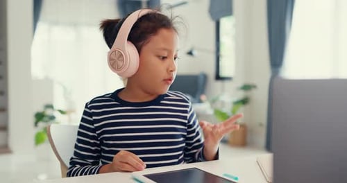 Girl Learning Online with Laptop and Headphones at Home