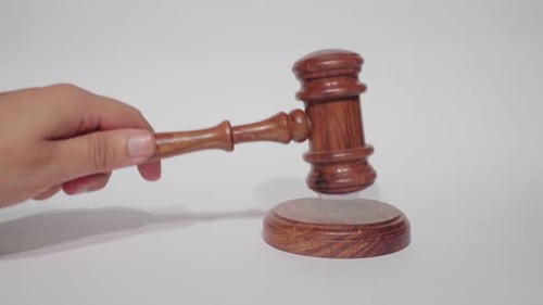 Wooden Judge's Gavel Being Struck on Block