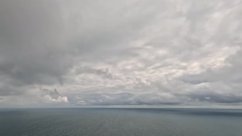 Timelapse of Dark Rain Clouds Moving in Overcast Grey Sky Over a Sea Horizon During Bad Weather