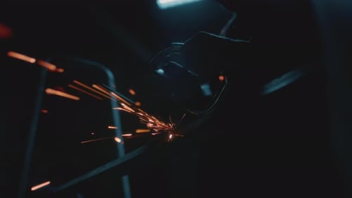 Mann, Industriearbeiter oder Bauarbeiter, schneidet Metall mit einer Produktionsanlage für Winkelschleifer
