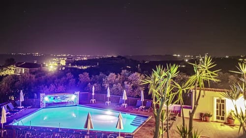 Timelapse of the night sky over a hotel pool
