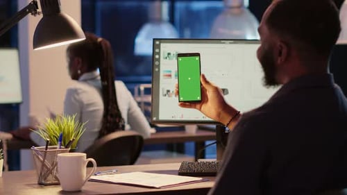 Man Holds Green Screen Phone at Desk