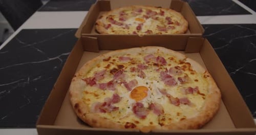 Two delicious pizzas in cardboard boxes