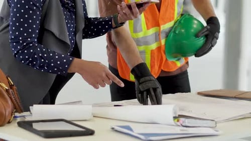 Architect and Construction Worker Reviewing Blueprints on Tablet