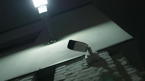 Security Camera Mounted on a Brick Wall at Night