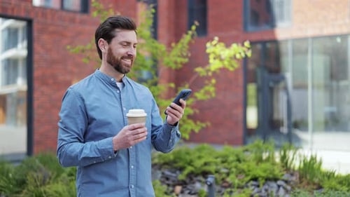 Man Using Smartphone with Coffee in Urban Setting