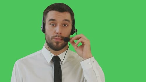 Young adult man talking using headset on green screen