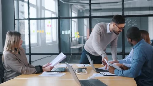 An angry boss scolds his subordinates. Professional workers are in the modern office together.