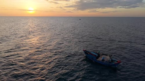 Sunrise travel scene with fishing boat at sea