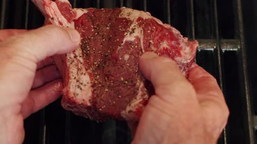 Close Up Hands Placing Seasoned Rare Beef Steak On Flame Grill Barbecue To Cook, 4K Slow Motion