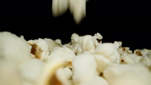 Close-up of falling popcorn background. Movement along the table covered with popcorn. Close-up.